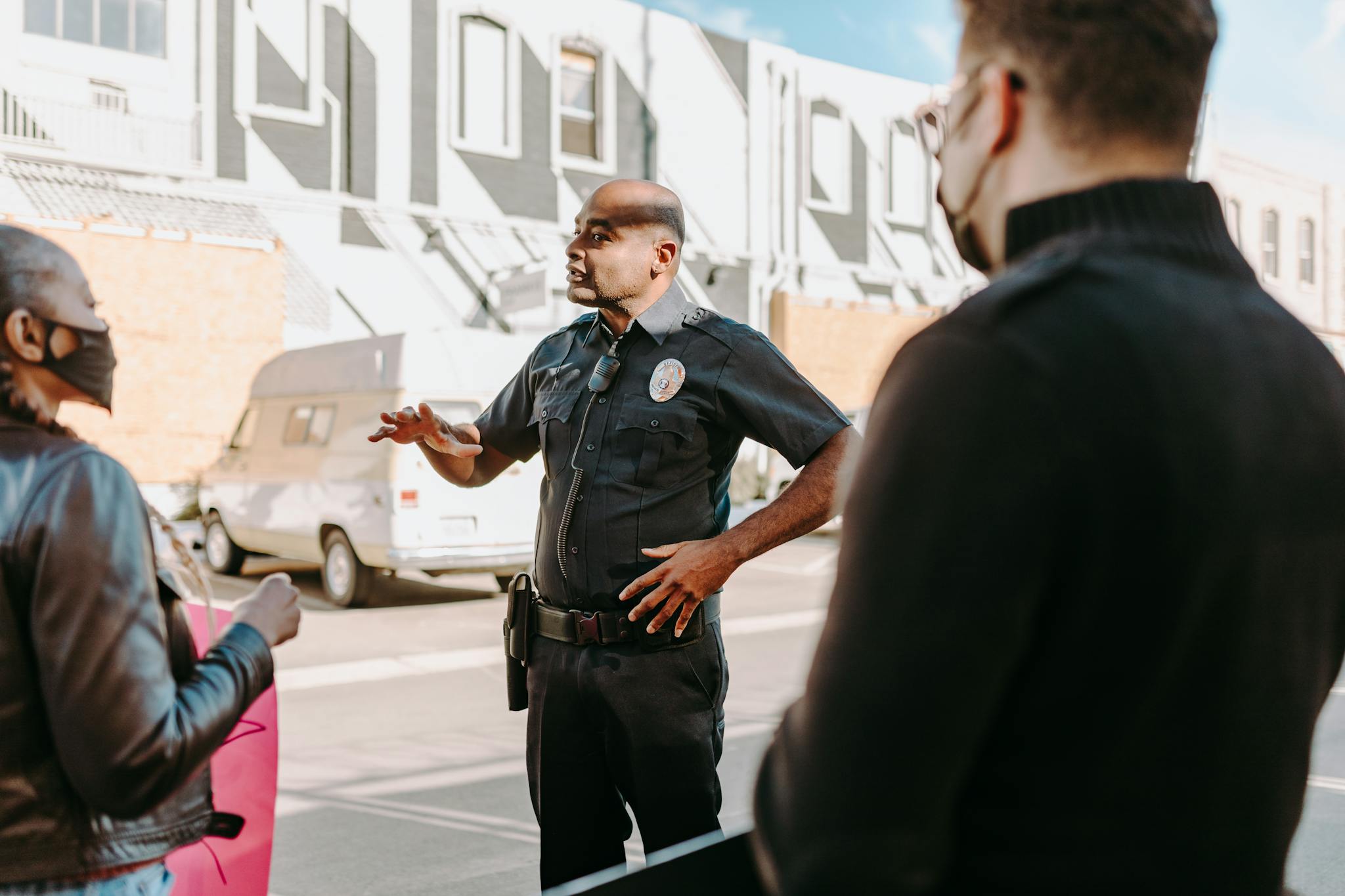 Photo by RDNE Stock project A police officer interacting with civilians during a peaceful protest in an urban setting.