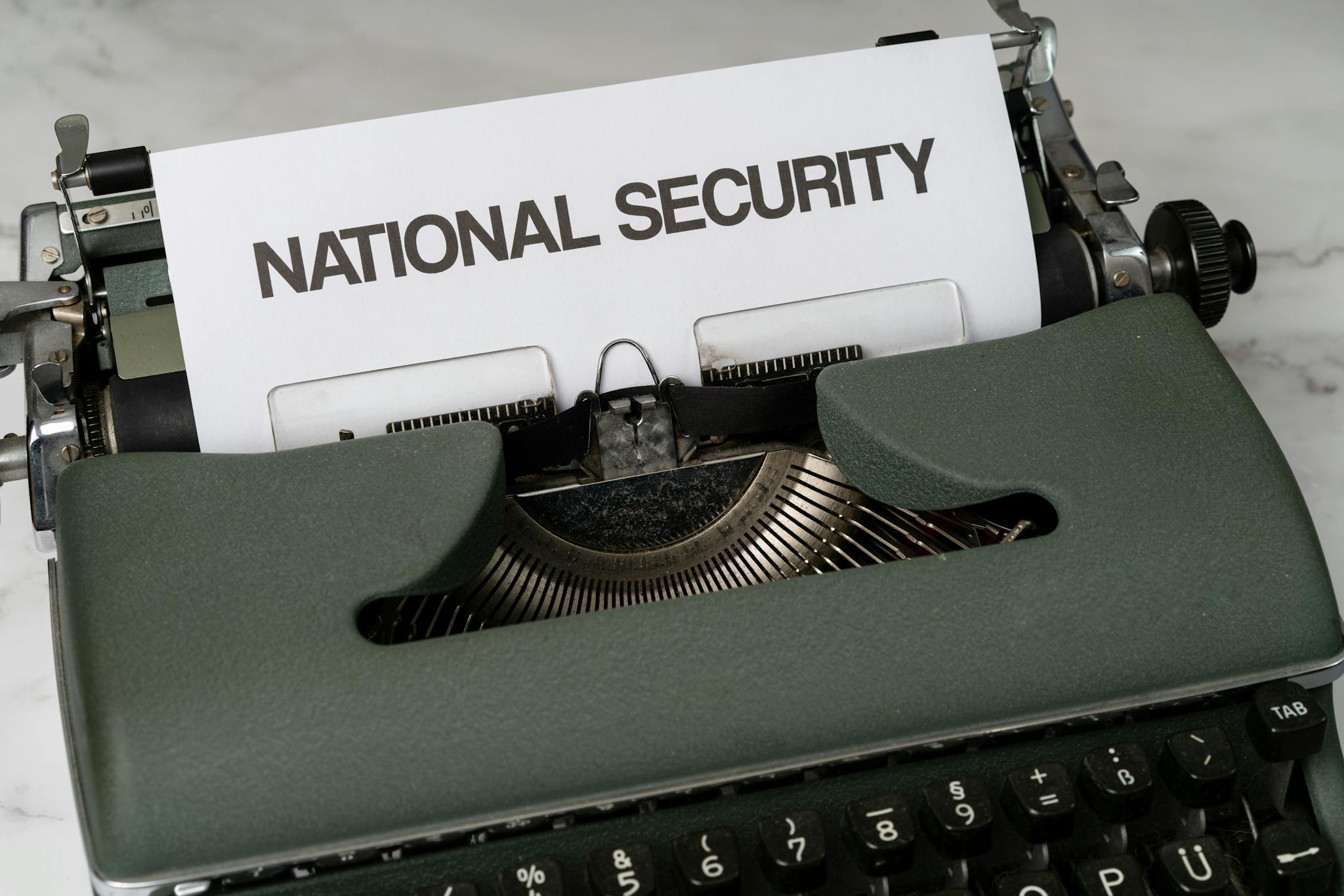Photo by Markus Winkler Close-up of a vintage typewriter with a paper marked 'National Security', symbolizing confidentiality.